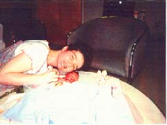Mother with face held next to her baby she just paid Tiller to kill