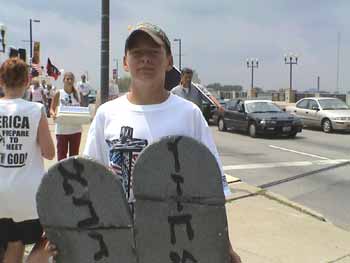 Jon Benham carrying a broken set of Ten Commandments